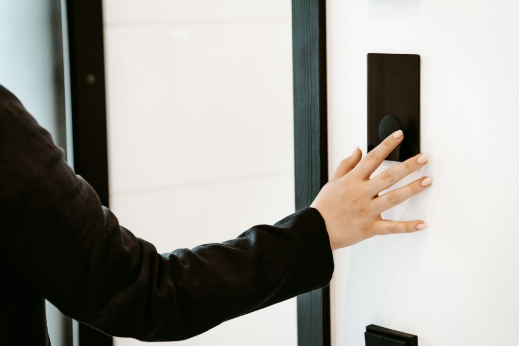 a person is pressing a button on a white wall